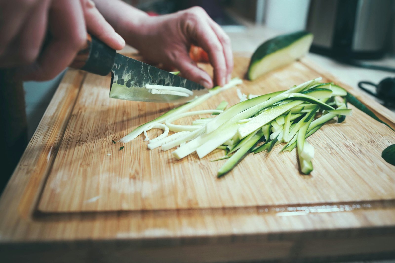 person slicing cucumber